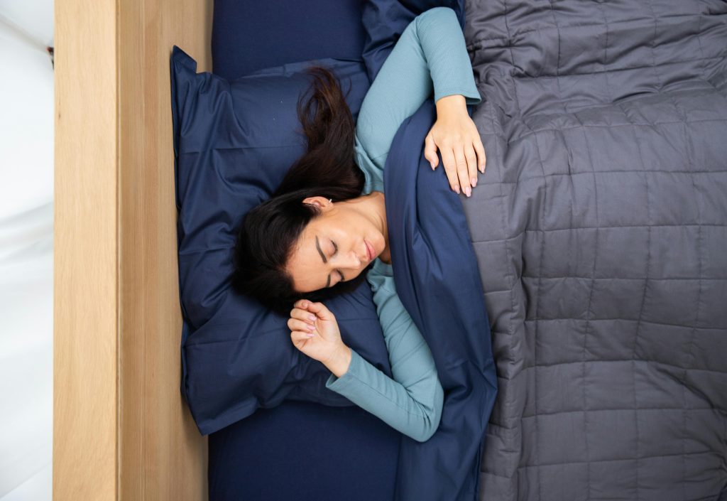 woman sleeping soundly on a blue bed
